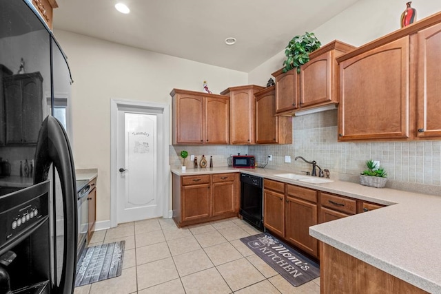 kitchen featuring sink, light tile patterned floors, black appliances, and decorative backsplash