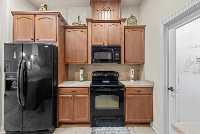 kitchen featuring black appliances, light tile patterned flooring, and backsplash