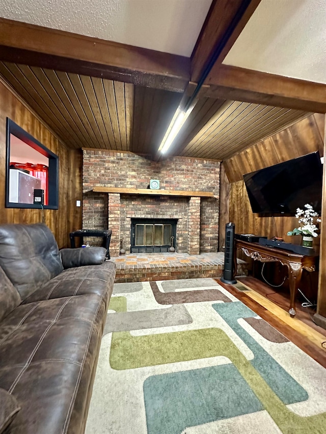 living room with wood walls, beamed ceiling, hardwood / wood-style floors, wood ceiling, and a brick fireplace