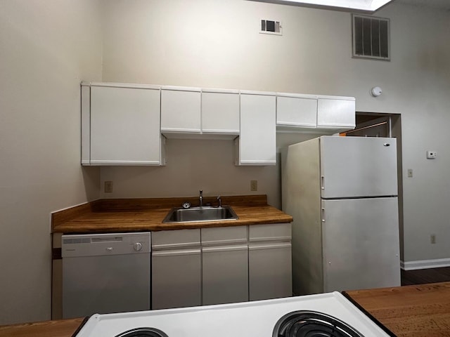 kitchen featuring wooden counters, white appliances, white cabinetry, and sink