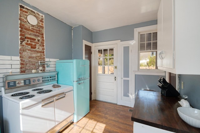 kitchen featuring white cabinetry, white appliances, and hardwood / wood-style flooring