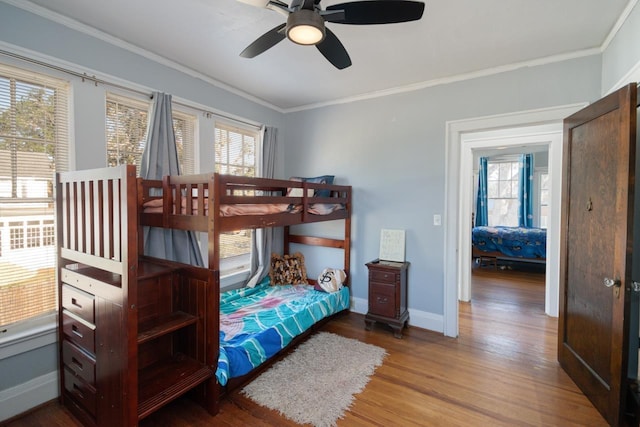 bedroom featuring ceiling fan, wood-type flooring, and multiple windows