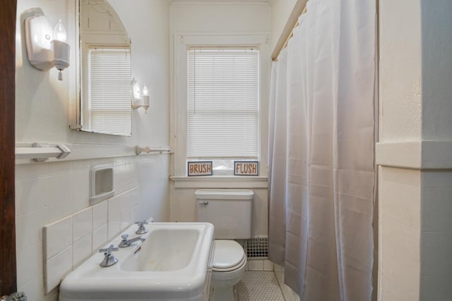 bathroom featuring tile patterned floors, sink, tile walls, and toilet