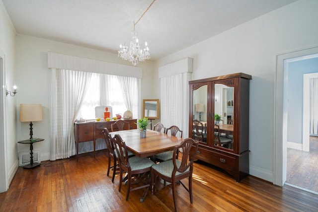 dining area with dark hardwood / wood-style flooring and a notable chandelier