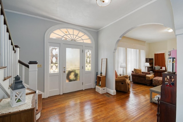 entrance foyer featuring a healthy amount of sunlight, wood-type flooring, and ornamental molding