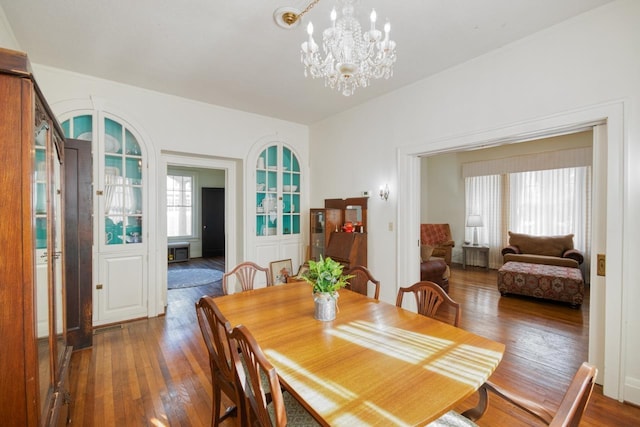 dining space with an inviting chandelier and dark wood-type flooring