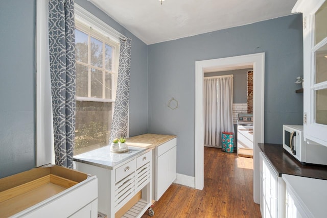 kitchen with hardwood / wood-style flooring and white cabinets