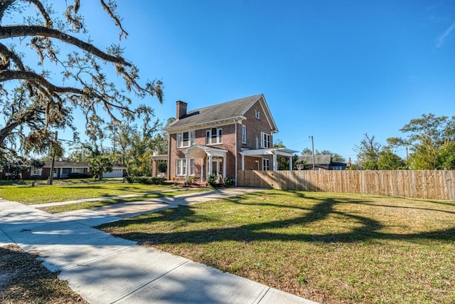 colonial-style house featuring a front yard