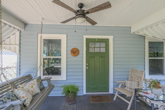 entrance to property with a porch and a ceiling fan