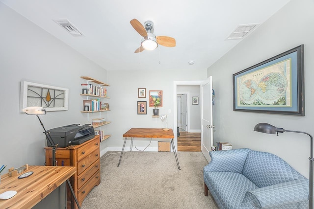 carpeted home office featuring baseboards, visible vents, and ceiling fan