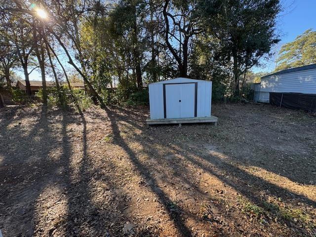 view of yard featuring a storage unit and an outdoor structure