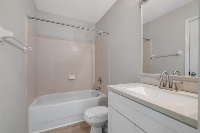 bathroom featuring toilet, wood finished floors, vanity, and bathing tub / shower combination