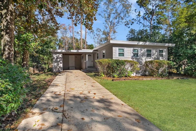 view of front of home with a carport, concrete driveway, and a front lawn