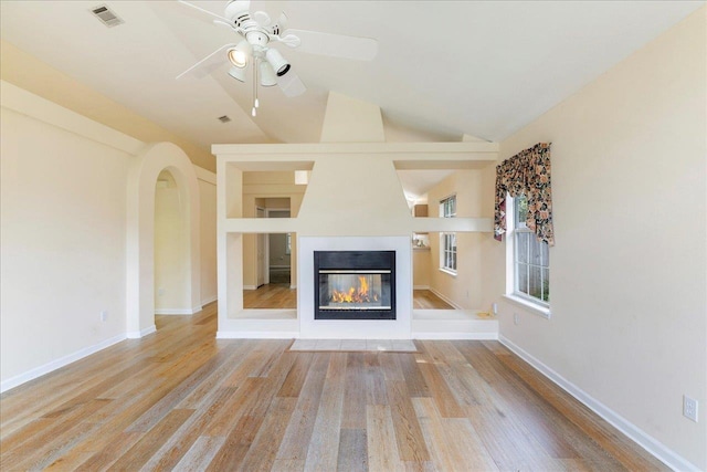 2942 Tewkesbury Trce, Tallahassee, FL 32309 - unfurnished living room with ceiling fan, a glass covered fireplace, wood finished floors, baseboards, and vaulted ceiling