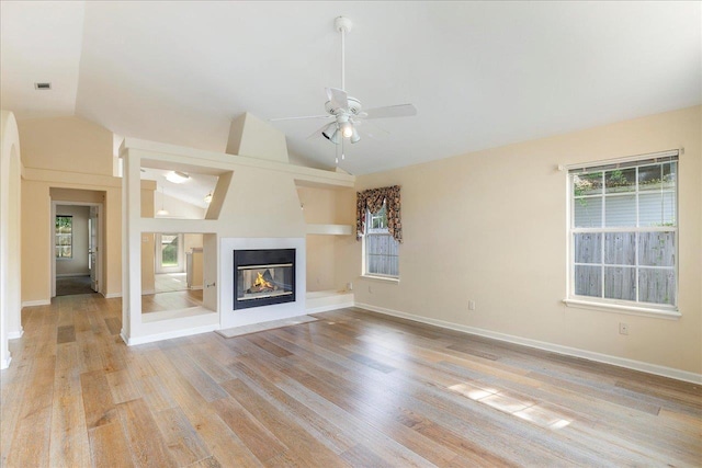 2942 Tewkesbury Trce, Tallahassee, FL 32309 - unfurnished living room featuring light wood finished floors, vaulted ceiling, a ceiling fan, a multi sided fireplace, and baseboards