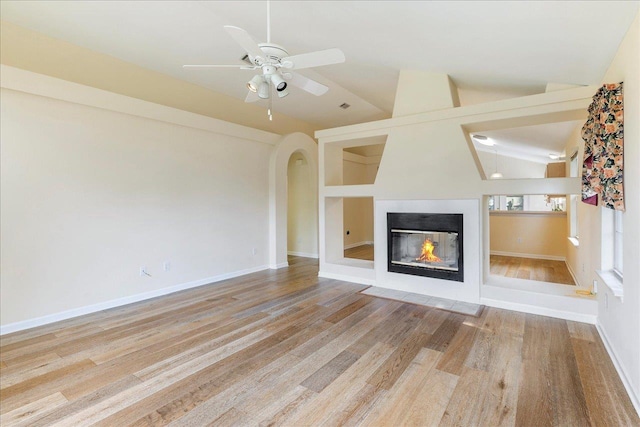 2942 Tewkesbury Trce, Tallahassee, FL 32309 - unfurnished living room featuring lofted ceiling, a ceiling fan, wood finished floors, a multi sided fireplace, and baseboards