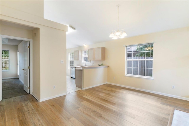 2942 Tewkesbury Trce, Tallahassee, FL 32309 - kitchen with a chandelier, stainless steel dishwasher, light wood-style floors, light countertops, and baseboards