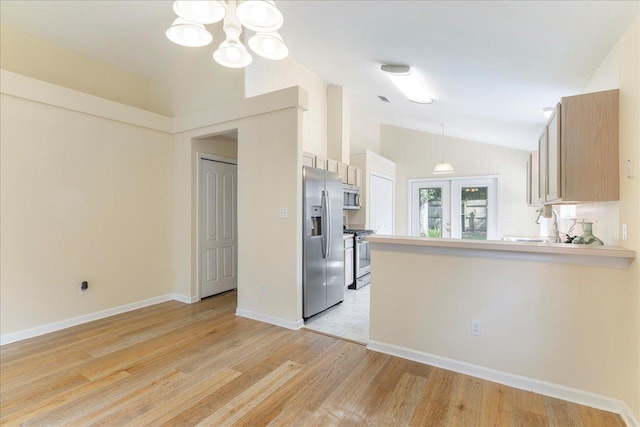 2942 Tewkesbury Trce, Tallahassee, FL 32309 - kitchen featuring appliances with stainless steel finishes, lofted ceiling, light wood-type flooring, a chandelier, and a peninsula