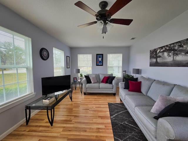 living room featuring a textured ceiling, light hardwood / wood-style floors, and ceiling fan