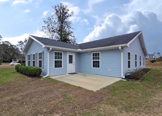 back of property with a yard and a patio