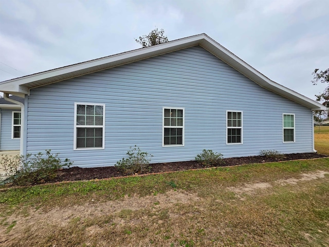 view of side of home with a yard