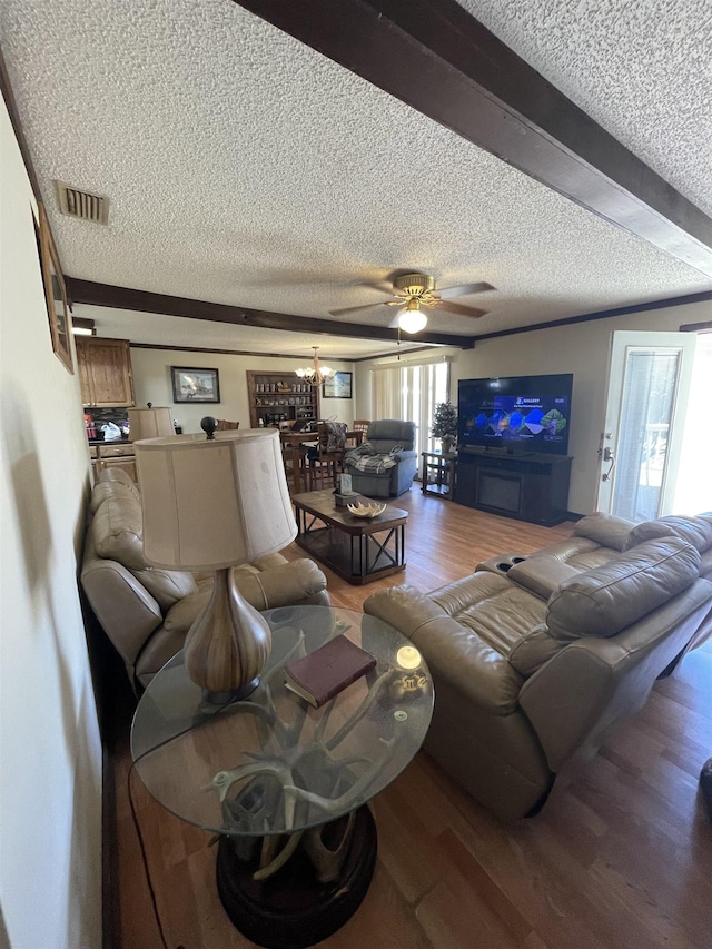 living area with wood finished floors, visible vents, and a textured ceiling