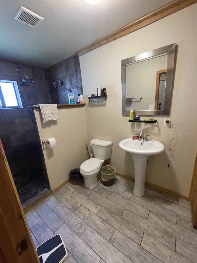 full bath with baseboards, visible vents, wood tiled floor, a walk in shower, and toilet