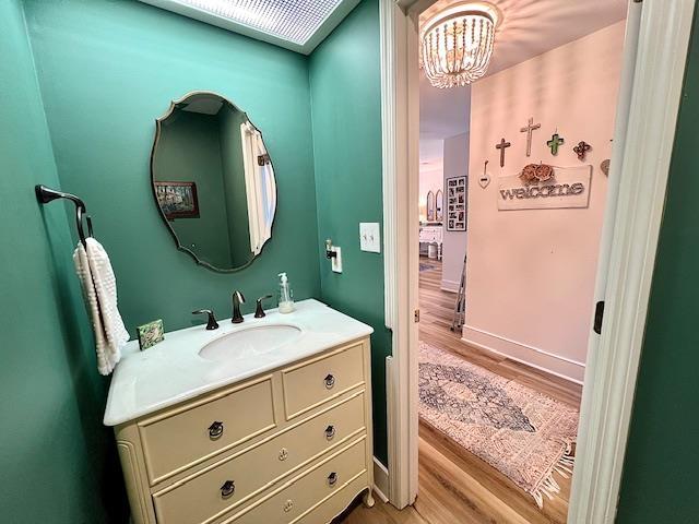 1814 Atlantis Pl, Tallahassee, FL 32303 - bathroom featuring wood finished floors, a chandelier, vanity, and baseboards