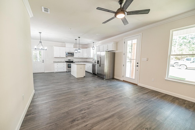 kitchen featuring hanging light fixtures, white cabinetry, appliances with stainless steel finishes, and a center island