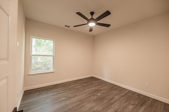 empty room with ceiling fan, dark wood-style flooring, visible vents, and baseboards