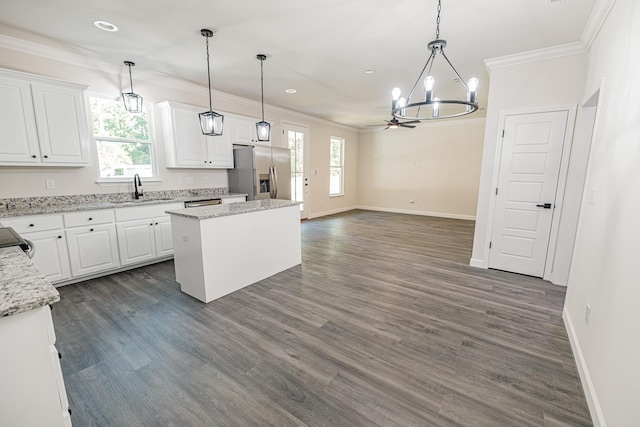 kitchen with a center island, white cabinets, a sink, and stainless steel fridge with ice dispenser