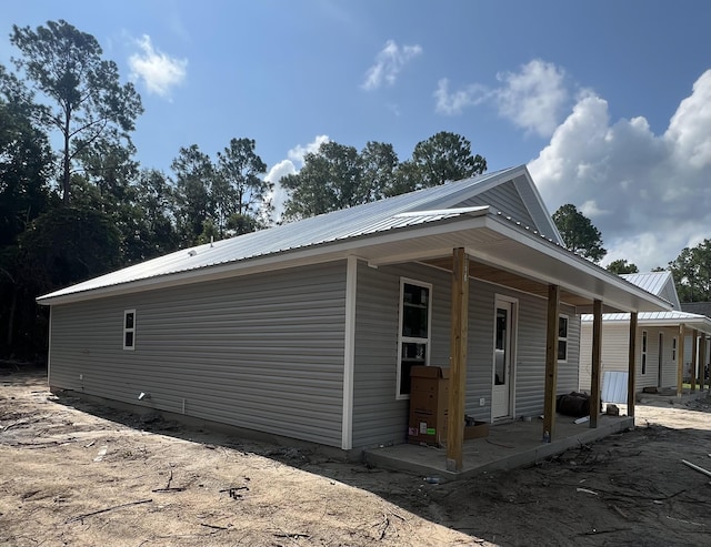 view of front of house with metal roof and a patio