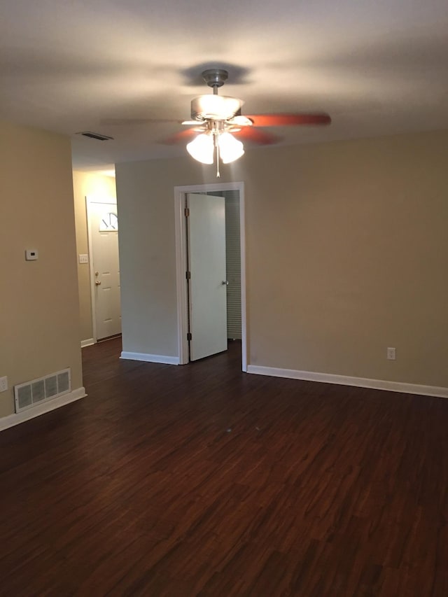unfurnished room featuring dark wood-style flooring, ceiling fan, and visible vents
