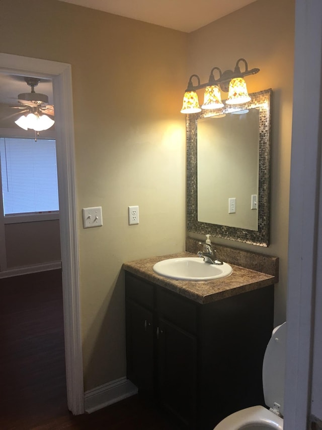bathroom with a ceiling fan, baseboards, vanity, and toilet