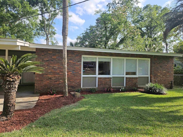 view of front of property with fence, brick siding, and a front yard