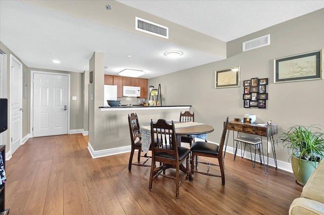 300 S Duval St Unit 1402, Tallahassee, FL 32301 - dining room featuring baseboards, wood finished floors, and visible vents