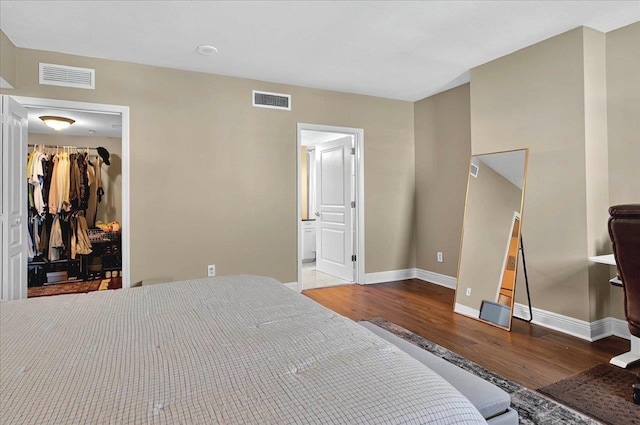 300 S Duval St Unit 1402, Tallahassee, FL 32301 - bedroom featuring a spacious closet, wood finished floors, visible vents, and baseboards