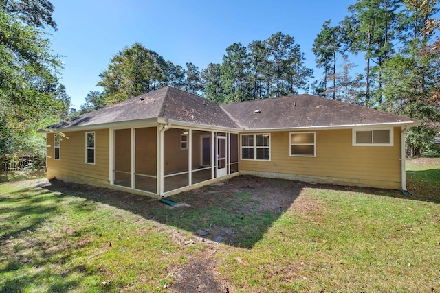 rear view of house featuring a yard and a sunroom