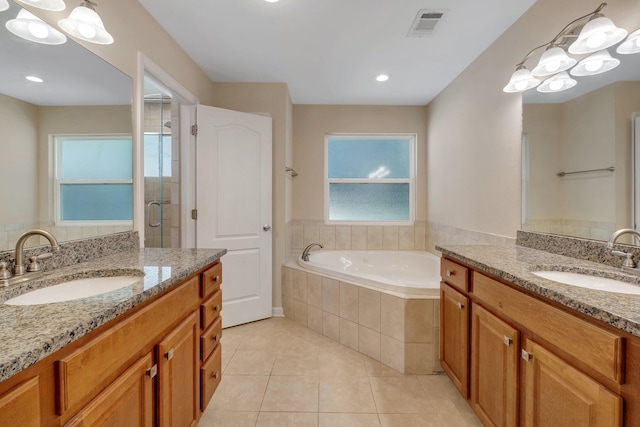 full bathroom with a garden tub, tile patterned flooring, visible vents, and a sink