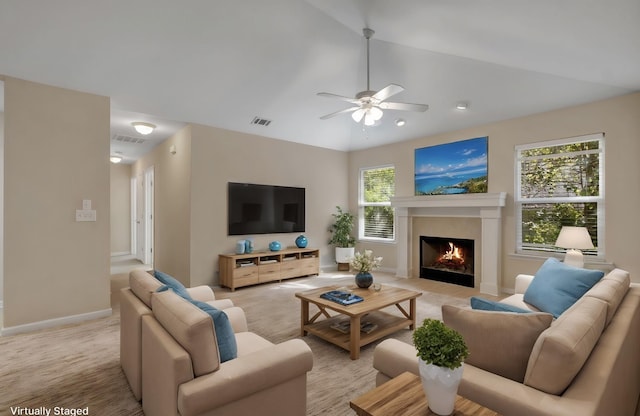 living area featuring light carpet, a fireplace with flush hearth, visible vents, and vaulted ceiling