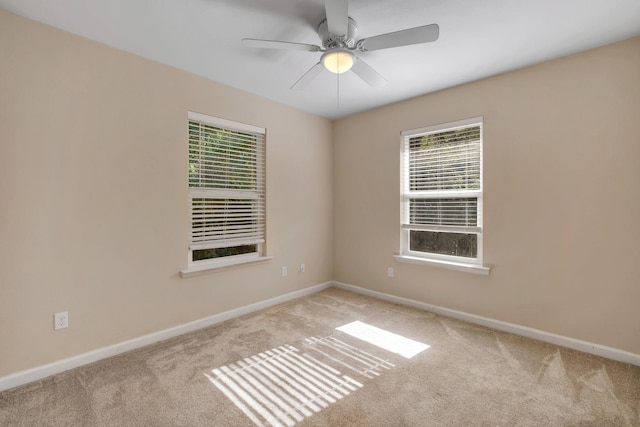 carpeted empty room featuring ceiling fan and baseboards