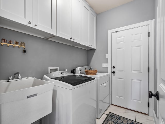 laundry area featuring washer and dryer, marble finish floor, cabinet space, and a sink