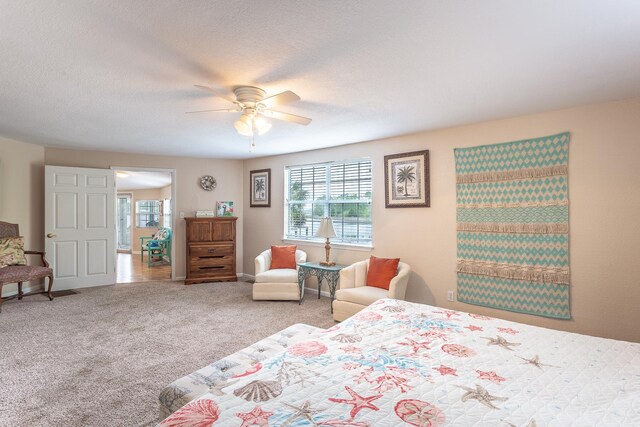 bedroom with carpet, a textured ceiling, and ceiling fan