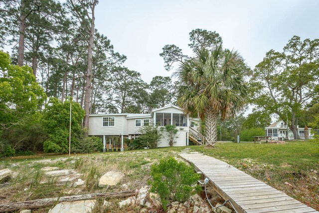 view of front of house with a front lawn and a sunroom