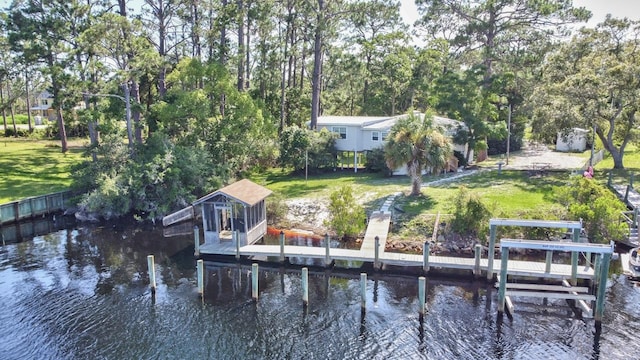 view of dock featuring a lawn and a water view