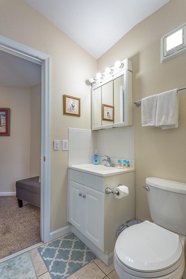 bathroom with toilet, tasteful backsplash, vanity, and tile patterned flooring