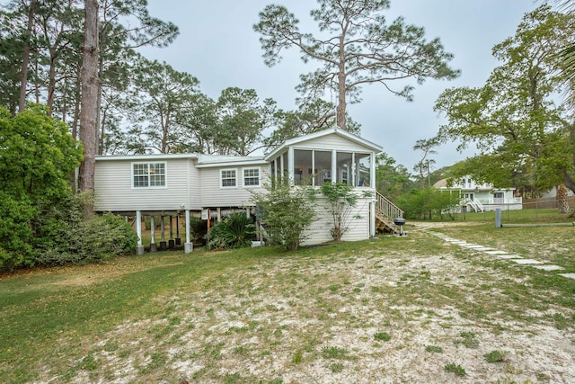 rear view of property with a sunroom and a yard