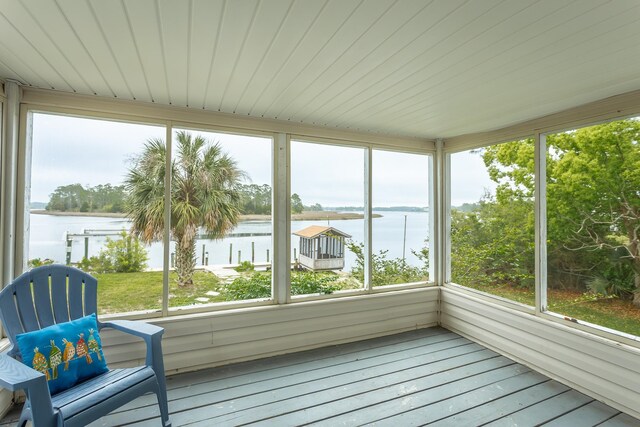 unfurnished sunroom featuring a water view