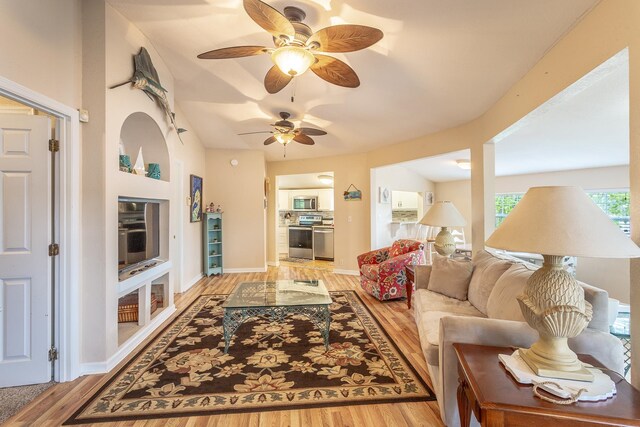 living room with ceiling fan and light hardwood / wood-style flooring