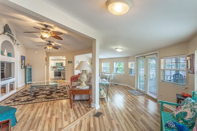 living room featuring ceiling fan and light hardwood / wood-style flooring